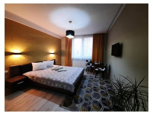 a hotel room with a bed and a table at N.D Global Alba Iulia in Alba Iulia