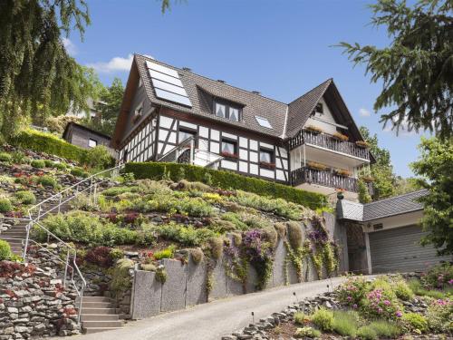 een huis op een heuvel met bloemen bij Cozy Holiday Home in Hallenberg with Terrace in Hallenberg
