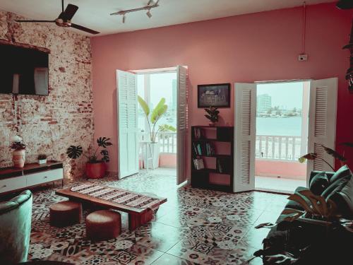 a living room with pink walls and a table at Casa Zahri Boutique Hostel in Cartagena de Indias