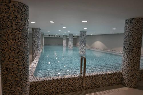 a large swimming pool in a hotel room at NOVAK apartman in Vrnjačka Banja