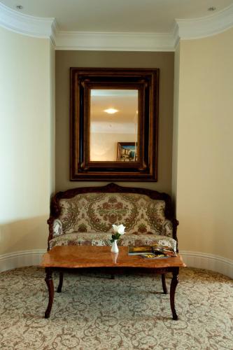 a couch in a room with a mirror and a table at Royal Princess Hotel in Dubrovnik