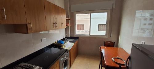 uma pequena cozinha com uma mesa e uma janela em El balcón del mediterráneo em M'diq