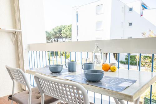 - une table à manger avec 2 bols bleus dans l'établissement CEL'STUDIO-Parking privé-Clim réversible -Balcon-Lave-linge-Lit - POINT ZERO, à La Grande Motte