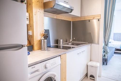 une cuisine avec une machine à laver et un évier dans l'établissement CEL'STUDIO-Parking privé-Clim réversible -Balcon-Lave-linge-Lit - POINT ZERO, à La Grande Motte