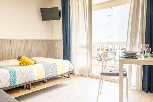 une chambre avec un lit et un balcon dans l'établissement CEL'STUDIO-Parking privé-Clim réversible -Balcon-Lave-linge-Lit - POINT ZERO, à La Grande Motte