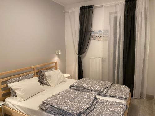 2 Betten in einem kleinen Schlafzimmer mit Fenster in der Unterkunft Słoneczny Nowy in Jastrzębia Góra