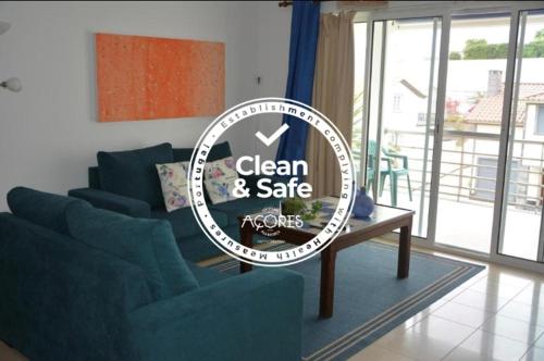 a sign in a living room with a couch and a table at Apartamento de Vila Franca do Campo in Vila Franca do Campo