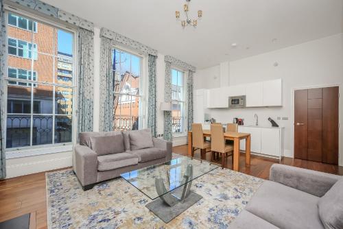a living room with a couch and a table at Tavistock Place Apartments in London