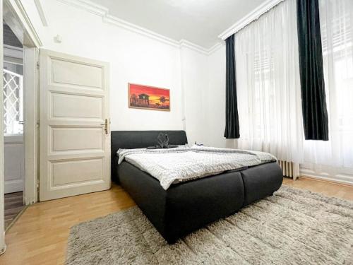 a bedroom with a bed in a room with a door at Pannónia Best Home in Budapest