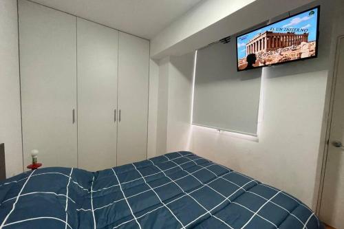 a bedroom with a bed and a tv on the wall at 6 - Departamento de 2 dormitorios en area turistica de Miraflores in Lima