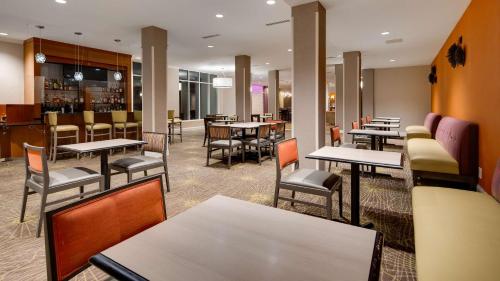 a restaurant with tables and chairs and a bar at Best Western Premier I-95 Savannah Airport/ Pooler West in Savannah