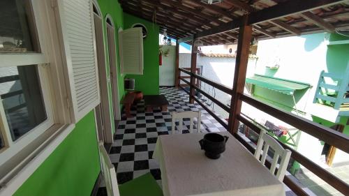 a room with a table and chairs on a balcony at Pousada Taquinha Paraty in Paraty