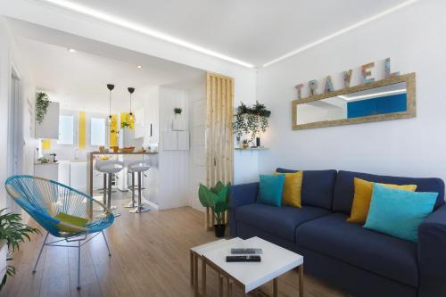 un salon avec un canapé bleu et une table dans l'établissement SMILE HÔME-Nid Panoramique VUE WOW ! SPAdéco - LoungeZEN - Terrasse ensoleillée - arrivée autonome - Netflix - emplacement idéal - Lumineux - rénové à neuf - Wifi Fibre -, à Montpellier