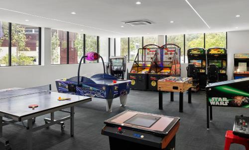 a room with a bunch of arcade games and ping pong tables at RACV Noosa Resort in Noosa Heads