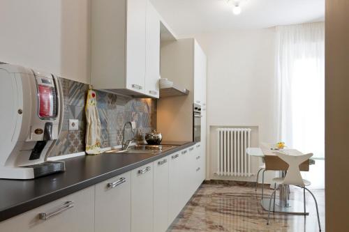 a kitchen with white cabinets and a sink at B&B Aquisgrana in Corridonia