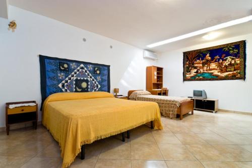 a bedroom with two beds and a painting on the wall at Open Space San Cusumano in Erice