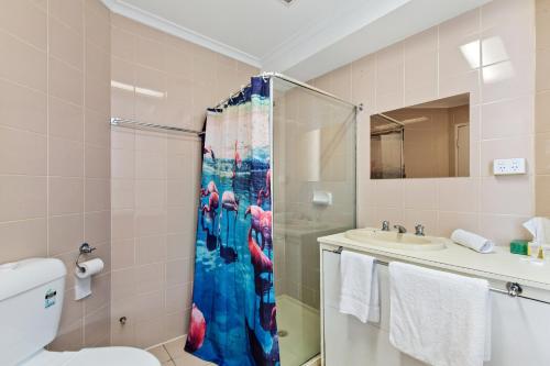 een badkamer met een douche, een toilet en een wastafel bij Cosmo on Bank in Adelaide