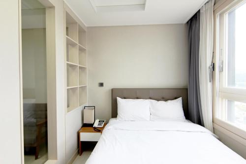 um quarto com uma cama e uma janela em AM Hotel em Pyeongchang