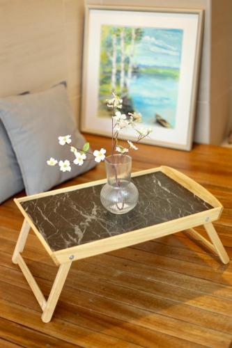 a wooden coffee table with a glass vase on it at Smell rose beach garden花语海沙滩花园 in Batu Ferringhi