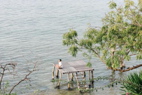 a person sitting on a table in the water at Plataran Menjangan Resort and Spa - CHSE Certified in Banyuwedang