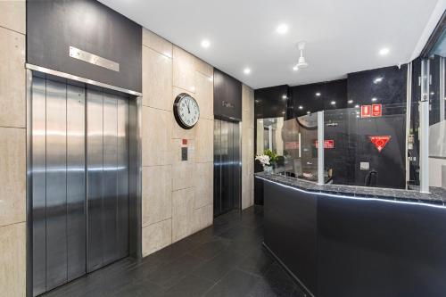 a lobby with a clock on the wall at Cosmo on Bank in Adelaide