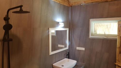 ein Bad mit einem WC, einem Spiegel und einer Lampe in der Unterkunft Margarita Beach in Khanom