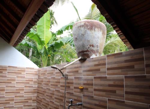 a bathroom with a shower with a stone head on the wall at Green Kubu Asri Villa in Nusa Penida