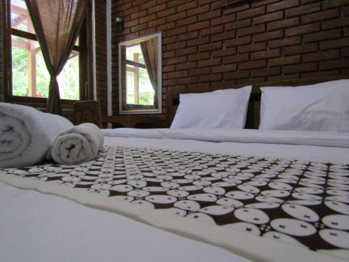 a bedroom with two beds with towels on them at Penginapan Udin Syariah Bukit Rhema in Magelang