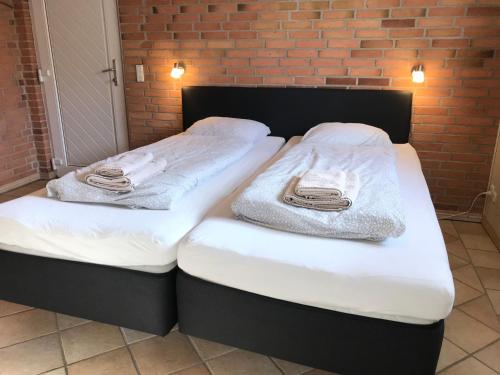 two beds sitting next to each other with towels on them at Egebjerggaard Bed & Breakfast in Sig