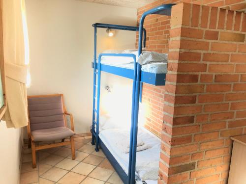 a room with two bunk beds against a brick wall at Egebjerggaard Bed & Breakfast in Sig