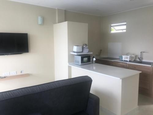 a living room with a white counter and a tv at Maka Bay Self Catering in Victoria