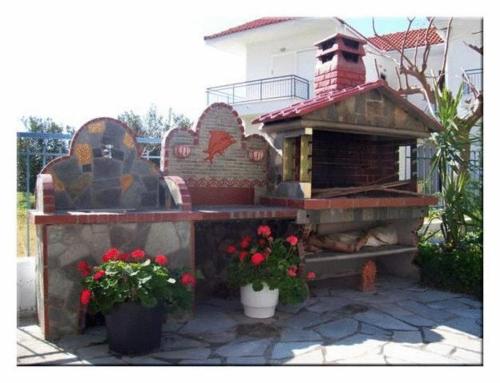 a bird house and a bench in a yard at Philoxenia Apartments in Kryonéri