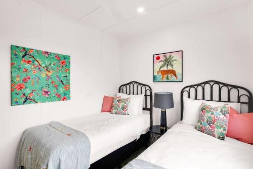 a bedroom with two beds and two pillows at Tropicana Bungalow - Retro Getaway in Cairns North
