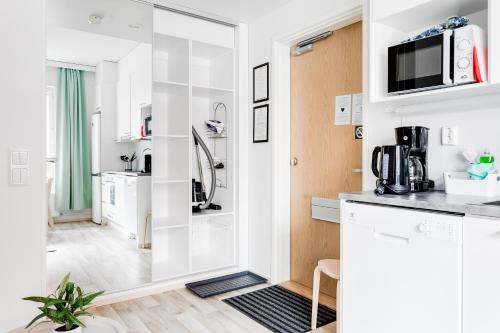 eine Küche mit weißen Wänden und einer Arbeitsplatte in der Unterkunft Hiisi Homes Tampere Armonkallio in Tampere