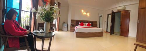 a woman sitting in a room with a bedroom at Westlake Tay Ho Hotel 696 Lạc Long Quân in Hanoi