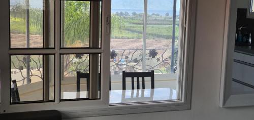 a room with a window with two chairs and a table at The Lake House in Migdal