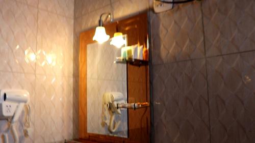 La salle de bains est pourvue d'un miroir et d'un téléphone mural. dans l'établissement bruhway hotel, à Addis-Abeba