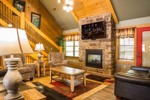 a living room with a stone fireplace and a table at A Hilltop Hideaway chalet in Gatlinburg