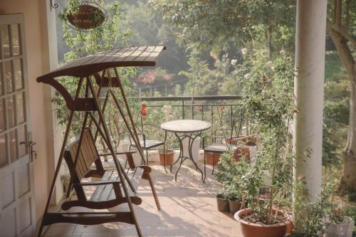 a porch with a table and a table and chairs at Dalat Terrasse Des Roses Villa in Da Lat