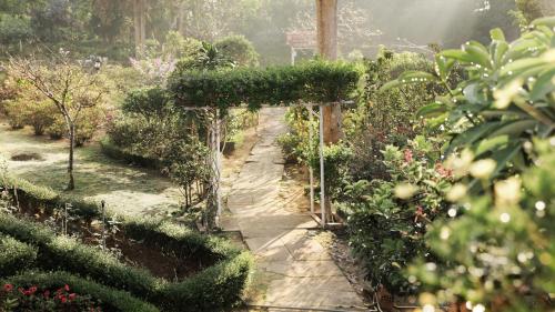 a garden with an arbor in the middle of a path at Dalat Terrasse Des Roses Villa in Da Lat