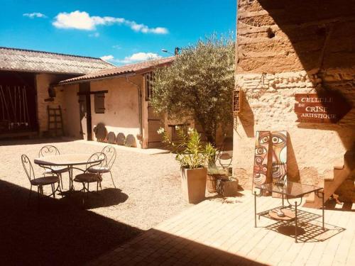 eine Terrasse mit einem Tisch und Stühlen vor einem Gebäude in der Unterkunft Le Gîte de la Batone in Messimy