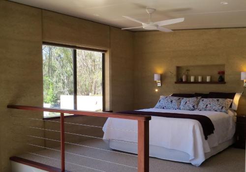 a bedroom with a bed with a desk and a window at Earth & Soul Retreat in Cannon Creek