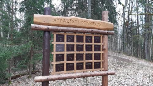 a sign in the middle of a forest at Atpūtas komplekss "Ratnieki" in Ratnieki