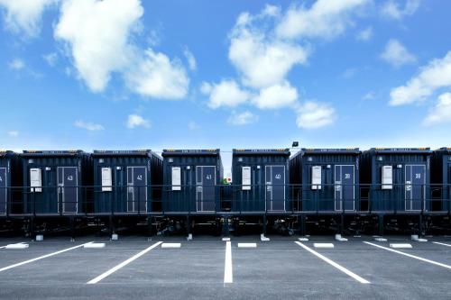 una fila de retretes portátiles en un estacionamiento en HOTEL R9 The Yard Miyakojima, en Isla Miyako