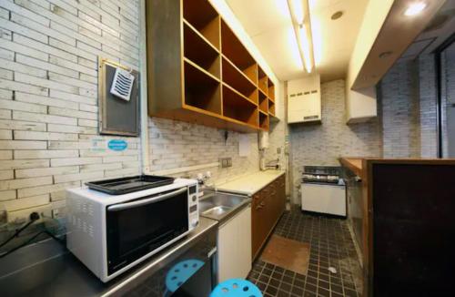 a small kitchen with a sink and a microwave at Exsasion Sugamo in Tokyo