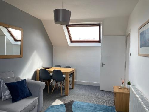 a living room with a table and a couch at Skerry View - Overlooking the Moray Firth - close to Beaches, Harbour, Shops and Restaurants in Lossiemouth