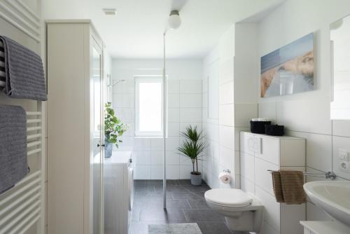 a white bathroom with a toilet and a sink at Schöner wohnen im Herzen Oldenburgs in Oldenburg