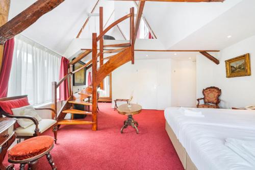 een slaapkamer met een bed en een trap in een kamer bij Ambassador City Centre Hotel in Haarlem