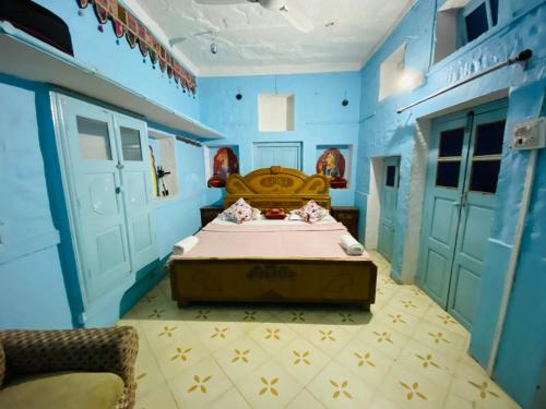 a bedroom with a bed in a blue room at Pushp Guest House in Jodhpur