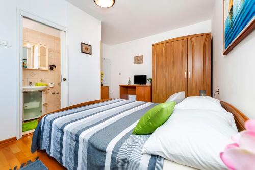 a bedroom with a bed with a blue and white striped blanket at Apartment & Rooms Graciela in Rovinj
